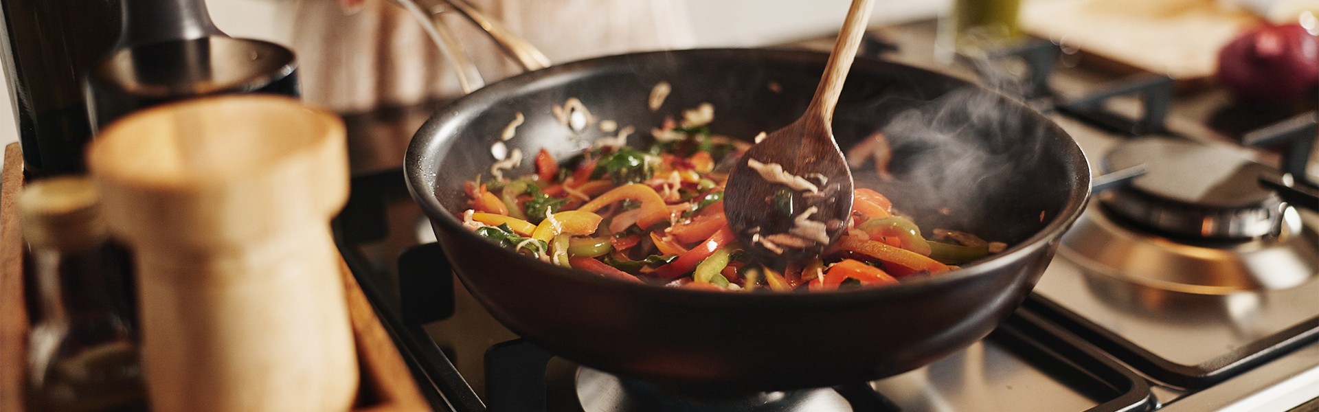 2527675083 Ruke, hrana i tava na tednjaku za pripremu stir fry jela, zdrava priprema obroka i recept za nutritivno bogat obrok u kuhinji.