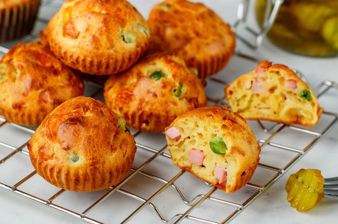 Delicious freshly baked homemade Savory muffins with Parmesan cheese, sausage or ham and green peas. Gourmet appetizer. Selective focus