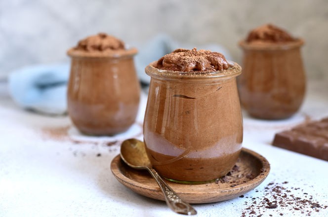 Delicious chocolate mousse in a vintage jars on a light slate, stone or concrete background.