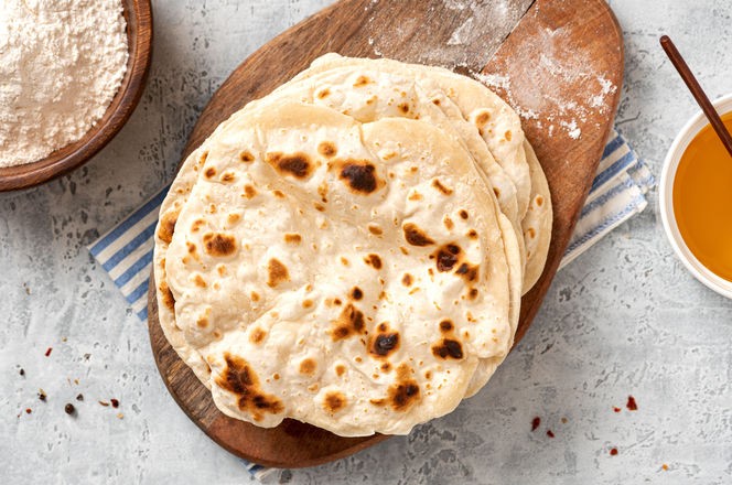 Homemade Roti Chapati Flatbread on gray concrete background top view. Freshly baked indian flatbread