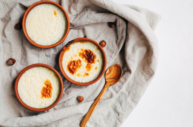 Turkish traditional dessert sutlac. baked rice milk pudding in a ceramic bowl on a light background. Copy space. Top view.