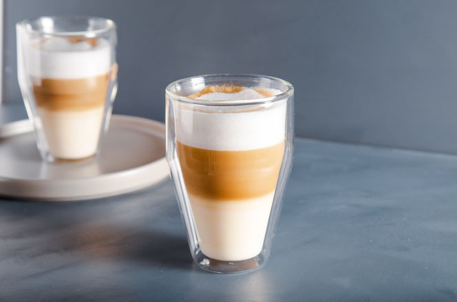 Perfectly gradient latte macchiato view over grey backdrop with copy space.