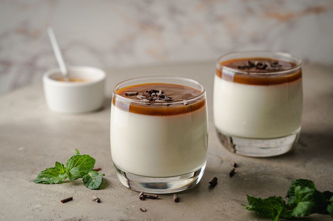 Vanilla panna cotta desert with caramel sause and chocolate in glasses